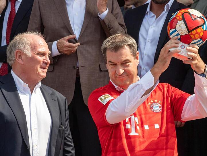 Bayerns Ministerpräsident Markus Söder (r) im FCB-Trikot und Vereinspräsident Uli Hoeneß posieren nach der Ehrung des FC Bayern München.