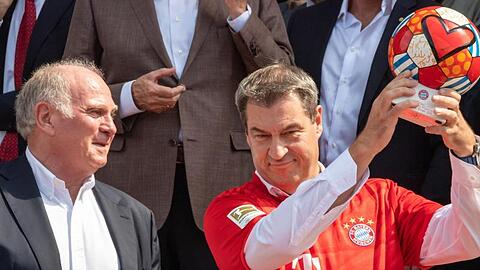 Bayerns Ministerpräsident Markus Söder (r) im FCB-Trikot und Vereinspräsident Uli Hoeneß posieren nach der Ehrung des FC Bayern München.
