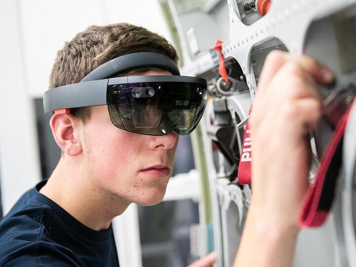 Ein Airbus-Auszubildender wird bei der Arbeit von einer Datenbrille unterstützt.