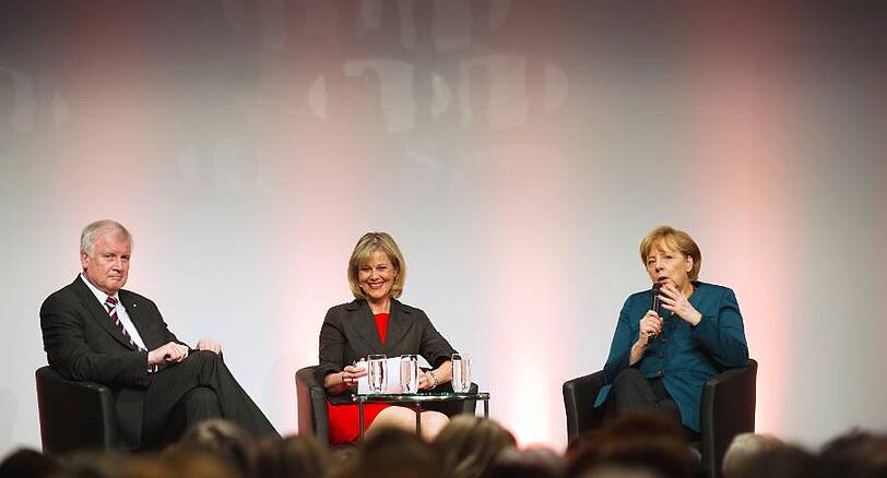 Vorgeführt: Horst Seehofer macht ein langes Gesicht, Nicola Brüning (Mitte), Chefin des Berliner BMW-Konzernbüros, hat ihn mit ihrer Moderation verblüfft, und Angela Merkel (r.) brät ihm eins über.