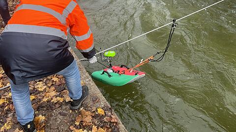 Ab in den Eisbach: Forscher der Helmut-Schmidt-Universität Hamburg lassen ein Mini-Surfbrett ins Wasser.