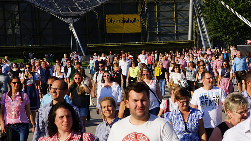 Dirndl, Lederhosn und viele Sonnenbrillen: die Fans auf dem Weg zum Konzert von Andreas Gabalier im Olympiastadion.