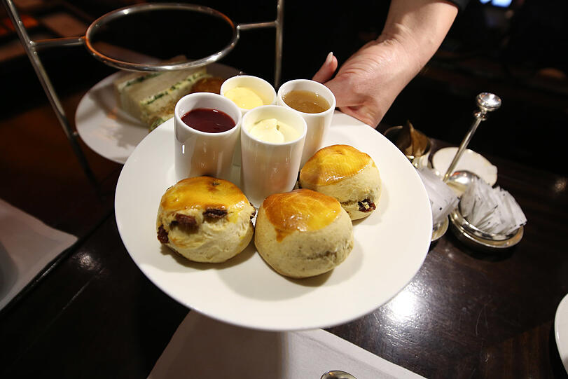 Scones mit Clotted Cream, zwei Marmeladen und Lemon Curd.