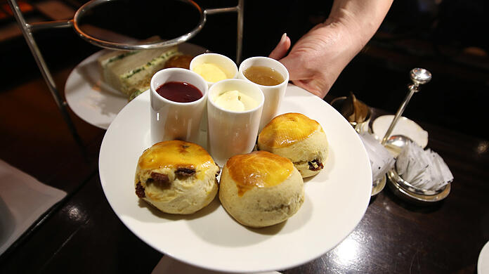 Scones mit Clotted Cream, zwei Marmeladen und Lemon Curd.