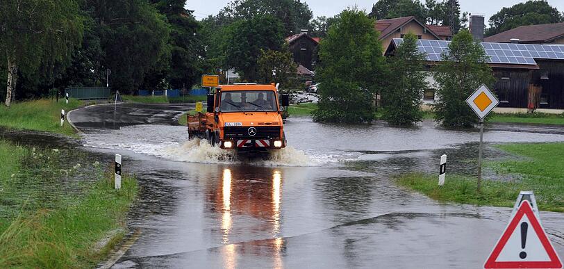 Ein Unimog fährt bei Rott (Oberbayern) im  Kreis Landsberg/Lech am Donnerstag über eine überflutete Straße.