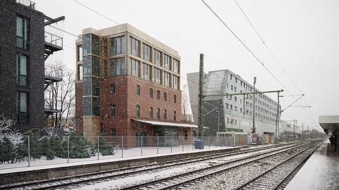 Zukunftsvision an den Gleisen in Moosach: Das modern aufgestockte Bahnhofsgebäude im Schneegestöber.