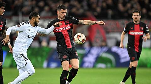 Leverkusens Granit Xhaka (M) und Agdams Juninho kämpfen um den Ball.