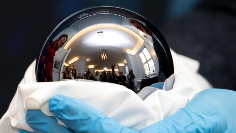 Ein Mann hält eine exakt ein Kilogramm schwere, hochreine Siliziumkugel in den Händen. Foto: Sven Hoppe Ein Mann hält eine exakt ein Kilogramm schwere, hochreine Siliziumkugel in den Händen. Foto: Sven Hoppe