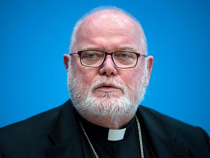 Kardinal Reinhard Marx vor einem blauen Hintergrund. Foto: Bernd von Jutrczenka/dpa/Archivbild
