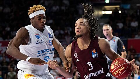 Münchens Carsen Edwards (r) kämpft um den Ball. Edawards war beim Münchner Sieg in der Euroleague bester Werfer.