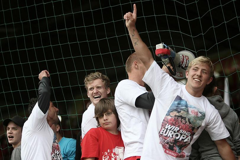 Die Mainzer Andre Schürrle (M) und Lewis Holtby (r) jubeln nach dem Abpfiff mit den Fans. Mainz gewann die Partie mit 2:1.