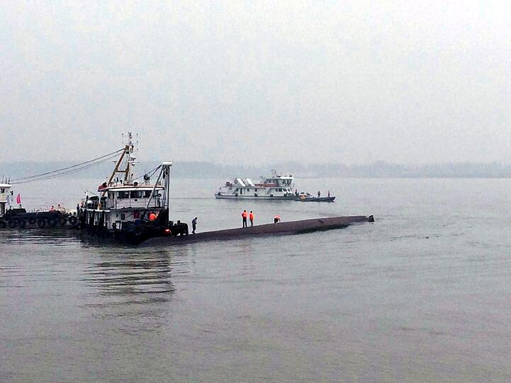 Die Suche nach dem Vermissten am Jangtse-Fluss: Wegen eines Tornados war ein Passagier-Schiff gekentert und liegt nun mit Kiel nach oben im Strom.