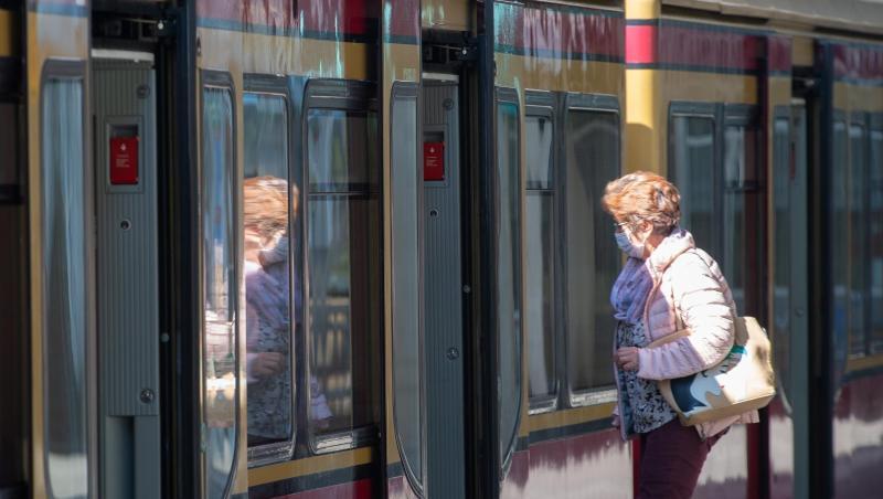 Eine Frau mit Mundschutz steigt in eine Berliner S-Bahn ein.