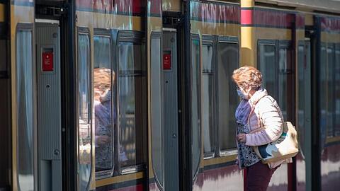 Eine Frau mit Mundschutz steigt in eine Berliner S-Bahn ein.