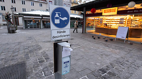 Vor einem Jahr noch undenkbar: Gähnende Leere und ein Desinfektionsmittel-Spender mit einem "Hände desinfizieren"-Schild auf dem Viktualienmarkt.