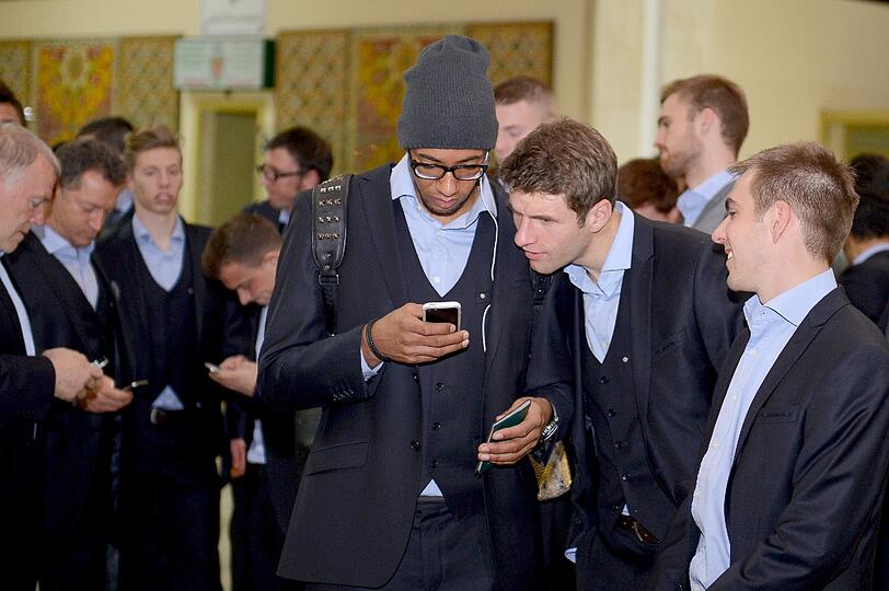 Erstmal das Handy checken: Jerome Boateng (l), Thomas Müller und Philipp Lahm in Agadir am Flughafen.