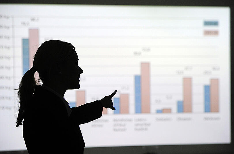 Eine Frau steht am 07.12.2010 in Berlin und erklärt eine mittels Beamer an die Wand projezierte Statistik.