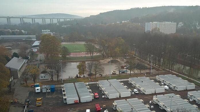 Auf einem Sportplatz im Ahrtal werden Wohncontainer für Flutopfer aufgestellt.