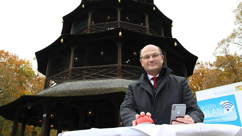 Minister Füracker startet das WLAN im Englischen Garten &ndash; mit einem symbolischen roten Knopf unter dem Chinaturm.