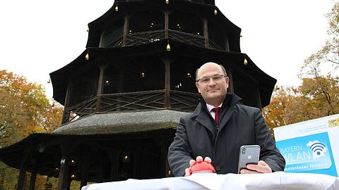 Minister Füracker startet das WLAN im Englischen Garten &ndash; mit einem symbolischen roten Knopf unter dem Chinaturm.
