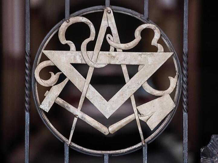 Die Symbole der Freimaurer (Zirkel, Winkel, Hammer und Kelle) sind im Tor zur Loge zu sehen. Foto: Andreas Arnold/dpa/Archivbild