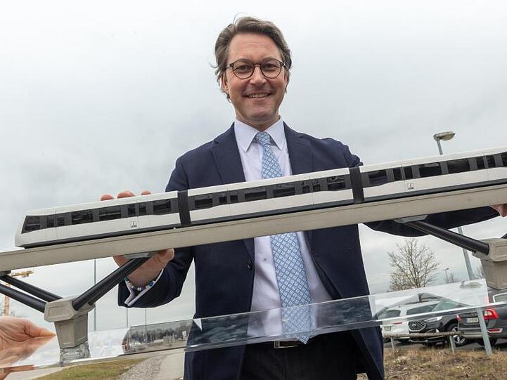 Andreas Scheuer (CSU), Bundesverkehrsminister mit einem Modell der Machbarkeitsstudie für eine Magnetschwebebahn.
