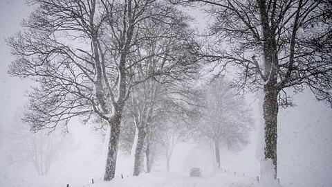 Ein Auto fährt über eine Schnee verwehte Landstraße. Foto: Lino Mirgeler