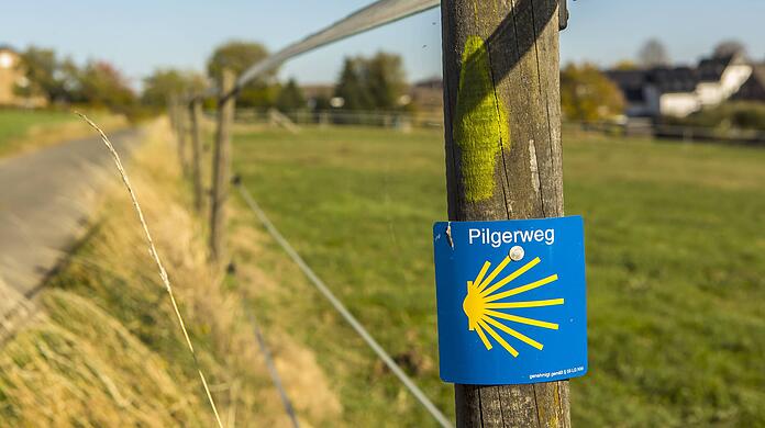 Gelbe Pfeile und die Europäische Jakobsmuschel weisen den Weg nach Santiago de Compostela.