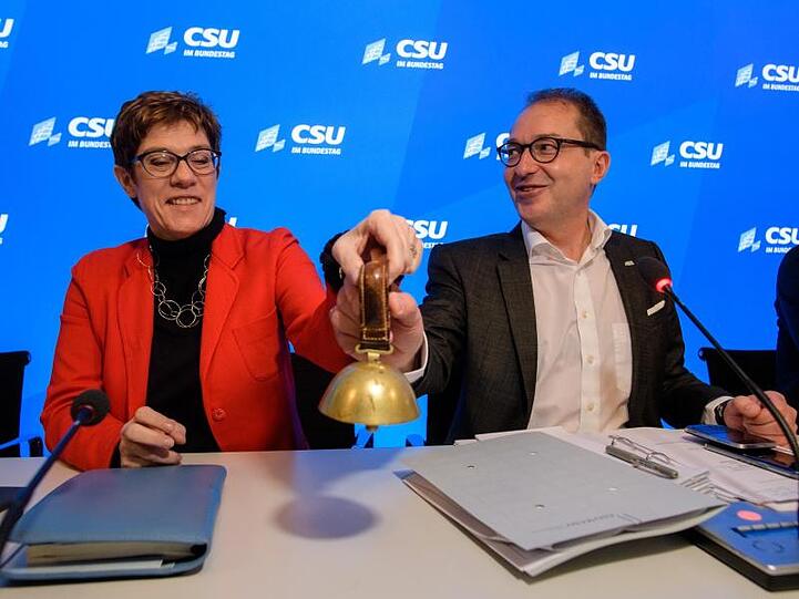 Alexander Dobrindt und Annegret Kramp-Karrenbauer läuten gemeinsam das Glöckchen zur Eröffnung des Gesprächs bei der CSU-Winterklausur im Kloster Seeon.