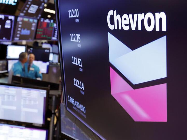 Das Logo von Chevron über einem Handelsposten auf dem Boden der New York Stock Exchange.