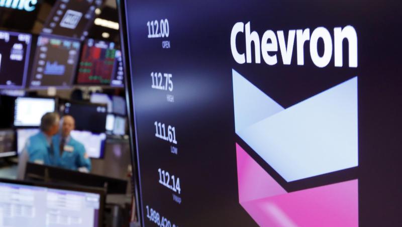 Das Logo von Chevron über einem Handelsposten auf dem Boden der New York Stock Exchange. Das Logo von Chevron über einem Handelsposten auf dem Boden der New York Stock Exchange.