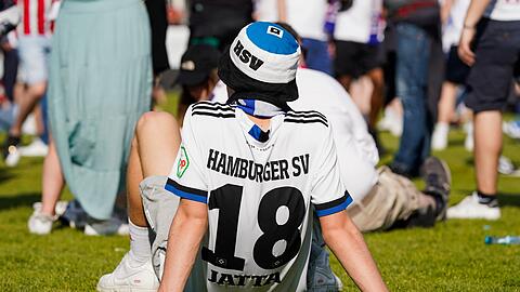 Nach der Nachricht des 3:2 von Heidenheim in Regensburg sitzt ein Hamburger Fan am Boden.
