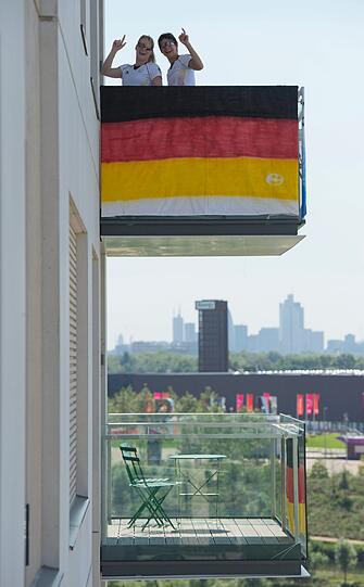 Der traumhafte Ausblick ist kaum zu toppen. Die Aussicht im deutschen Quartier ist absolut goldverdächtig. Vor allem, wenn wie derzeit in London mal die Sonne scheint. Der Hausschmuck fällt beim deutschen Team eher konservativ aus. Deutsche Flaggen hängen an den Balkonen. Die Italiener glänzen mit Kunstbildern an den Balkonen. Die Australier aber übertreffen alle anderen: vor ihrem Quartier stehen gigantische Emus und Kängurus aus Plastik.