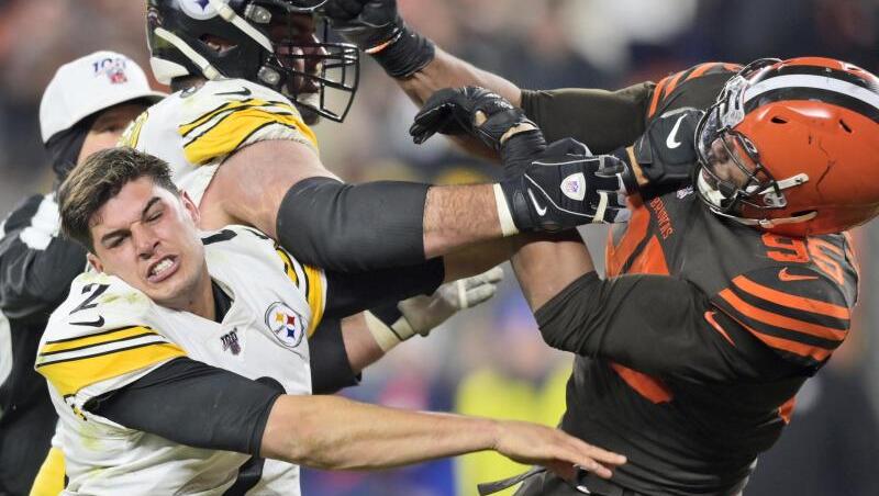 Myles Garrett (r) hatte mit dem Helm von Mason Rudolph (l) den Steelers-Quarterback attackiert. Myles Garrett (r) hatte mit dem Helm von Mason Rudolph (l) den Steelers-Quarterback attackiert.