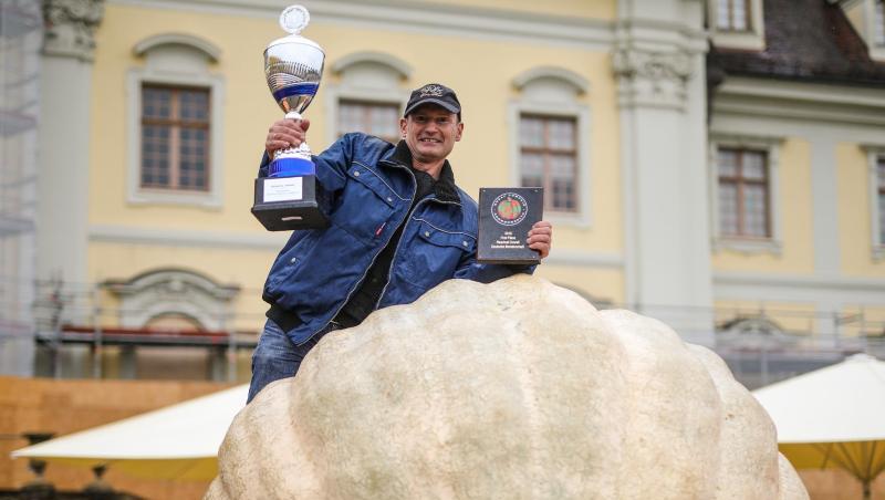 Michael Asam aus Heretshausen präsentiert als Sieger seinen 687,5 Kilogramm schweren Gewinner-Kürbis. Foto: Christoph Schmidt/dpa
