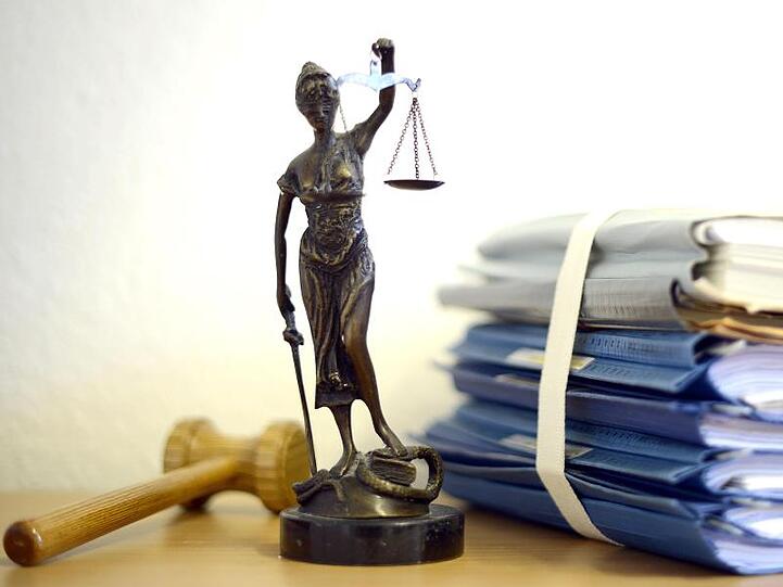 Justitia mit Holzhammer und Aktenstapel. Foto: Volker Hartmann/Archivbild