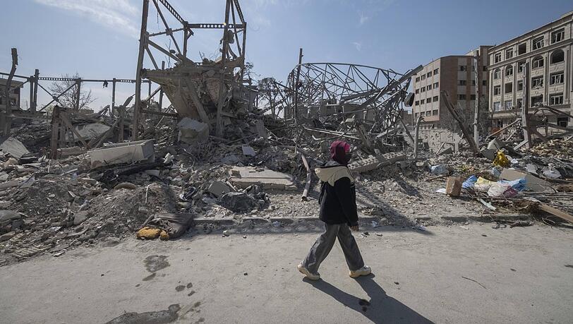 Eine Iranerin geht an einer v&ouml;llig zerst&ouml;rten Polizeistation in Teheran vorbei.