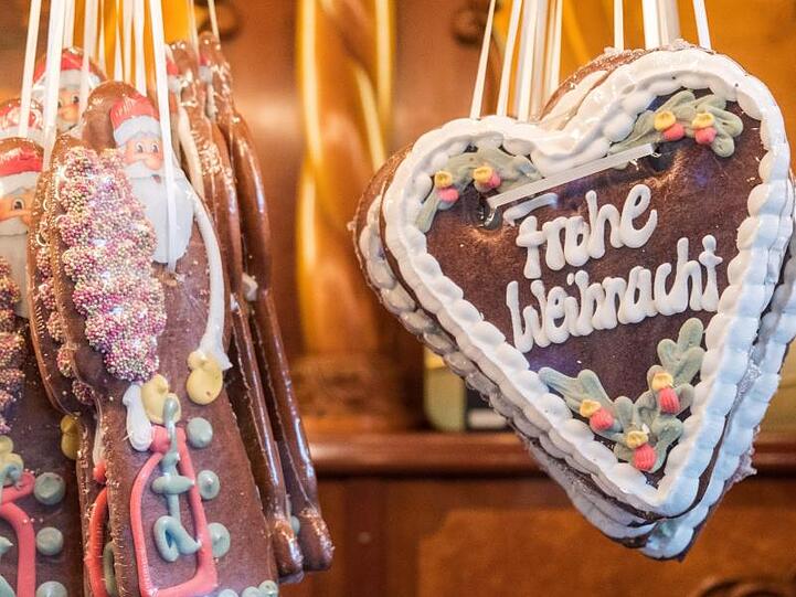 Figuren und Herzen mit der Aufschrift "Frohe Weihnacht" aus Lebkuchen. Foto: Daniel Bockwoldt/dpa