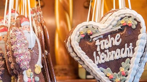 Figuren und Herzen mit der Aufschrift "Frohe Weihnacht" aus Lebkuchen. Foto: Daniel Bockwoldt/dpa