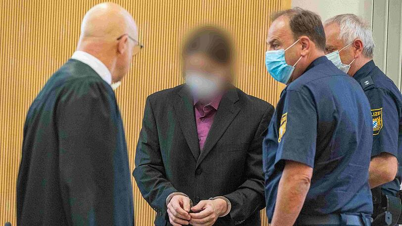 Der Angeklagte (Zweiter von links) im Verhandlungssaal neben Polizisten und seinem Verteidiger Michael Haizmann (links). Acht Jahre nach dem gewaltsamen Tod von Maria Baumer hat vor dem Landgericht Regensburg der Mordprozess gegen ihren Verlobten begonnen.