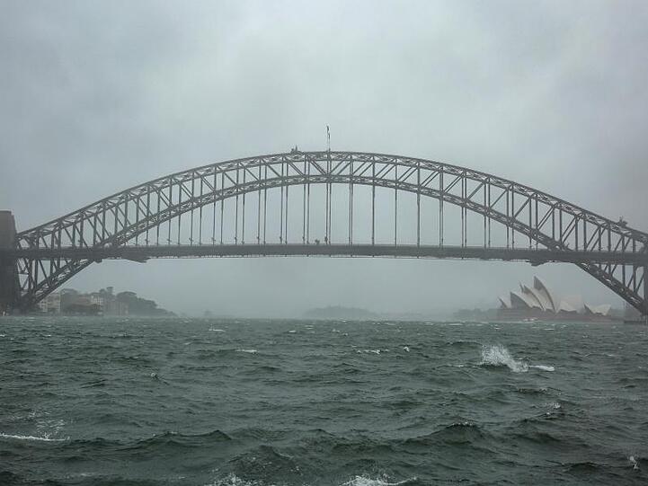 Winde peitschen das Wasser auf: Sydneys Harbour Bridge versinkt im Regenschleier.