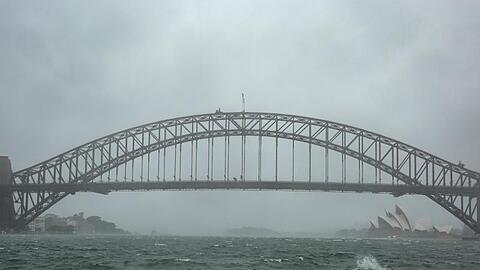 Winde peitschen das Wasser auf: Sydneys Harbour Bridge versinkt im Regenschleier.