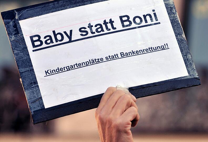 Demonstranten stehen mit Plakaten am Stachus in München (Vorbild der Demonstrationen ist die amerikanische Protestbewegung «Occupy Wall Street» («Besetzt die Wall Street»), die sich gegen das Finanzsystem und große Teile der Bankenwelt wendet.