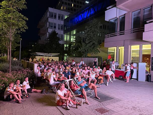 Auf Bierb&auml;nken, Strandst&uuml;hlen oder einfach auf dem Boden, vor Maisha&rsquo;s Kitchen in Giesing fieberten die Fans mit dem deutschen Team mit.