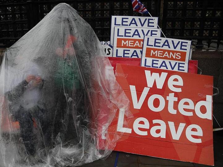Ein gut gegen den Regen geschützter Pro-Brexit-Demonstrant vor dem Parlament in London.