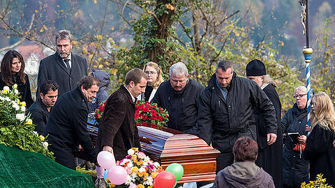 Bunte Blumen und Luftballons schmücken das Grab, in das der Sarg von Oleg Popow in Egloffstein hinabgelassen wird. Der weltbekannte Clown galt als einer der großen Clowns der Zirkusgeschichte. Die Bilder der Beerdigung.