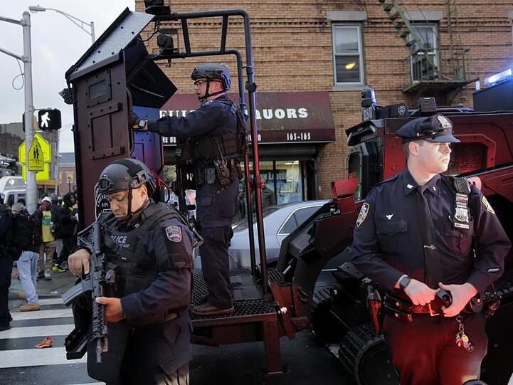 Schwer bewaffnete Polizisten sichern während der stundenlang andauernden Schießerei einen Straßenzug in Jersey City.