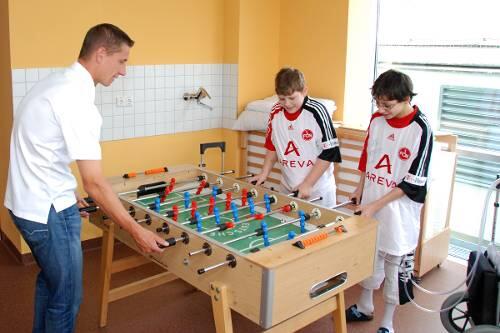 Beim Kickern bezwangen die Jungs ihr Idol. Der Kasten, der sie am Leben hält, steht rechts auf dem Boden.