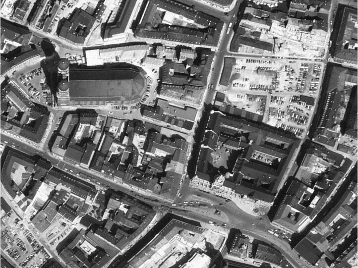 1956: Der Wiederaufbau schreitet voran. Hinterm Rathaus parken Autos auf dem &bdquo;Marienhof&ldquo;.