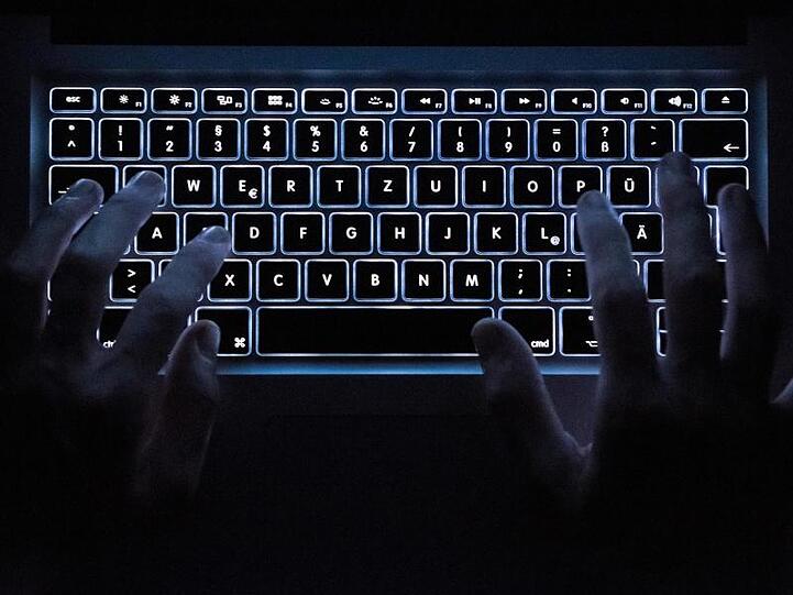 Ein Mann benutzt die Tastatur eines Notebooks. Foto: Silas Stein/dpa/Illustration